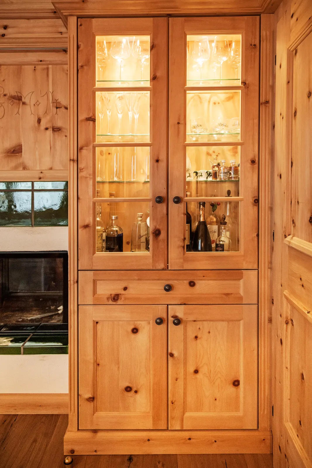 Beleuchteter Vitrinenschrank aus hellem, astigem Holz